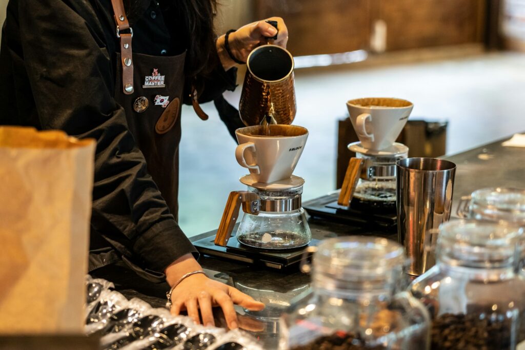 person pouring coffee on coffee cup
